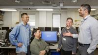 Four member of the Desktop Support team having a discussion.